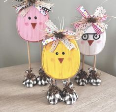 three wooden birds with bows on their heads are standing in the shape of pumpkins