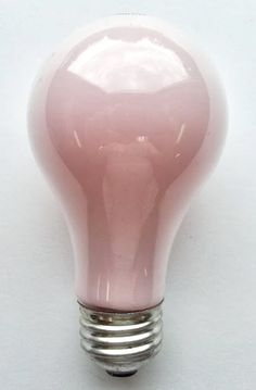 a pink light bulb sitting on top of a white table