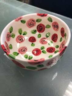 a white bowl with red and green flowers on it