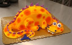 a cake shaped like a dinosaur sitting on top of a table