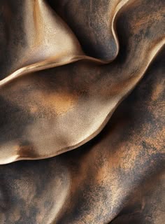 a close up view of a brown and gold fabric with some folds on it's surface