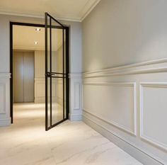 an empty room with white walls and trimmings on the wall, as well as a glass door leading to another room