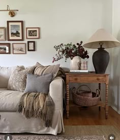 a living room filled with lots of furniture and pictures on the wall above it's coffee table