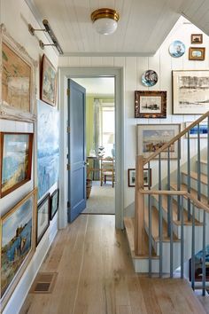 an entry way with stairs and pictures on the wall above it, along with a blue door that leads to another room