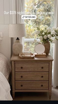 a bed room with a dresser and a mirror next to a lamp on a table