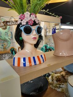 a mannequin head wearing sunglasses and a flower crown on top of it's head