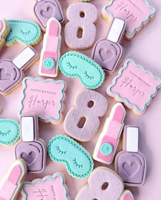 decorated cookies are arranged in the shape of numbers and other items on a pink surface
