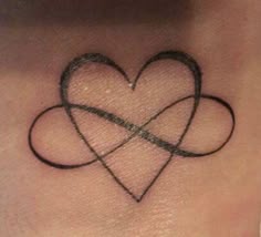 a small heart tattoo on the side of a woman's neck with two intertwined hearts
