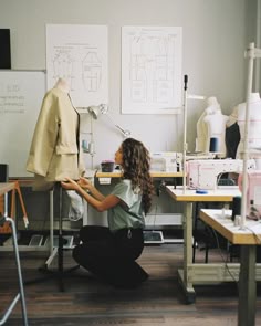 a woman sitting on the floor in front of sewing machines