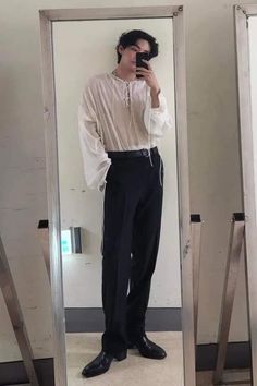 a man standing in front of a mirror taking a selfie with his cell phone