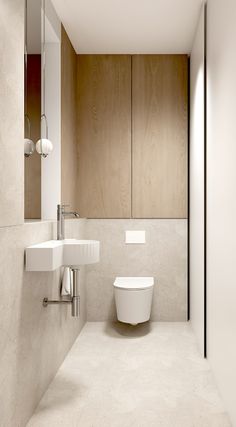 a white toilet sitting next to a bathroom sink in a room with wood paneling