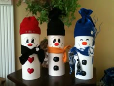 three snowmen made out of wine bottles on a table