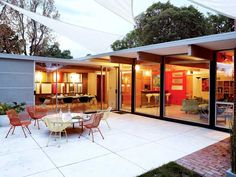 an outdoor dining area with patio furniture and glass doors that open up to the backyard