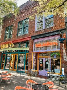 an outdoor cafe with tables and chairs on the sidewalk in front of a brick building