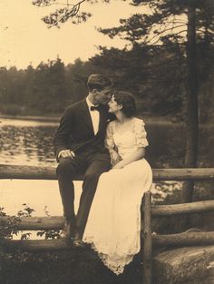 an old black and white photo of a couple sitting on a bench