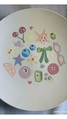 a white plate with various colored drawings on the side and numbers in the middle,