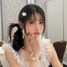 a young woman sitting at a table with her hands on her face