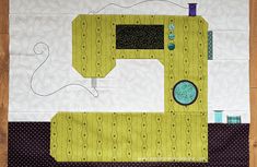 a sewing machine sitting on top of a piece of fabric next to a wooden floor