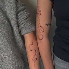 two people with matching tattoos on their arms