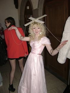 a woman in a pink dress is holding something on her head
