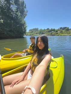 two people sitting in yellow kayaks on the water