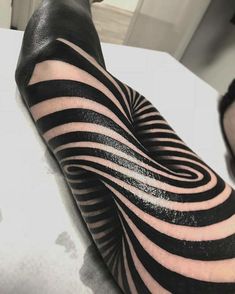 a person with black and white tattoos on their arm