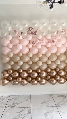 the balloon wall is decorated with pink and gold balloons