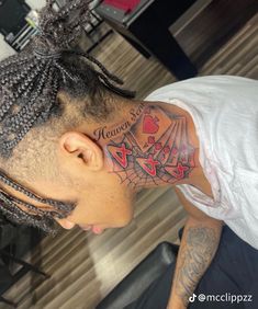 a man with tattoos on his neck and head is looking down at the floor in front of him