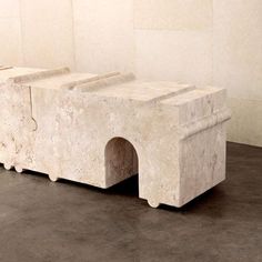 three stone benches sitting on top of a cement floor