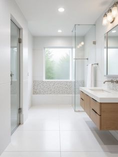 a white bathroom with two sinks and a shower