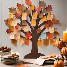 a family tree with lots of leaves and place cards attached to the tree's branches