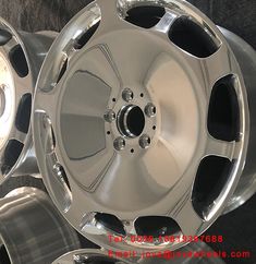 four new chrome wheels are stacked on top of each other in this photo, one is shiny and the other is polished
