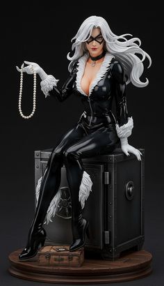 a statue of a woman in black catsuit sitting on top of a box with pearls