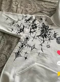 a white hoodie with black designs on it