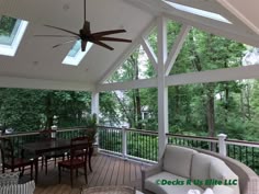 a covered porch with furniture and ceiling fan