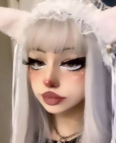 a close up of a person with white hair and cat ears on their head wearing makeup