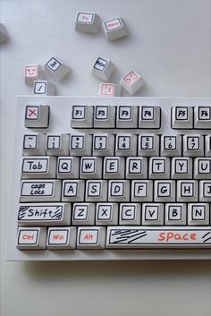 a computer keyboard sitting on top of a table covered in magnets and paper letters