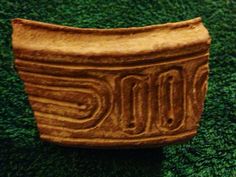 a ceramic object sitting on top of a green carpet