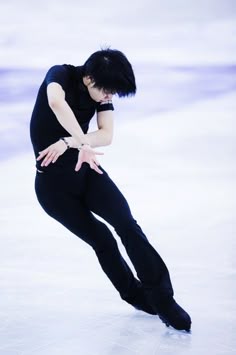 a man skating on an ice rink with his hands behind his back as he leans forward