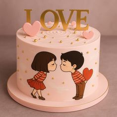 a cake decorated with two people kissing on the top and gold lettering that says love