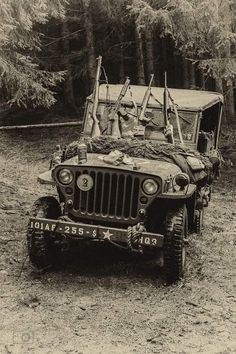 an old jeep is parked in the woods