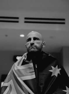a bald man with a flag draped around his shoulders