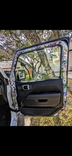the door is open and there is a tree in the back window on this truck