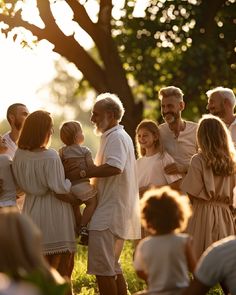 a group of people standing around each other in front of a tree with the sun shining on them