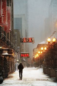 a person walking down a street in the snow