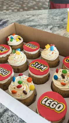 cupcakes decorated with candy and candies are in a box on the table