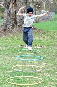 a young boy is jumping in the air with his arms and legs spread out as circles are arranged around him