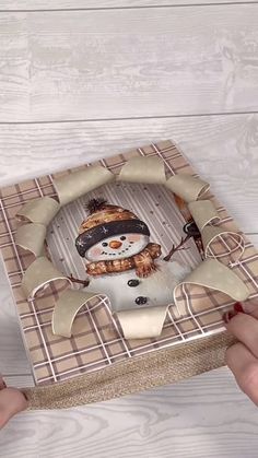 someone is holding a box with a snowman on it