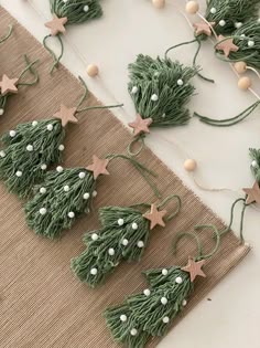 green christmas tree decorations with white balls and stars on the top, along with twine string