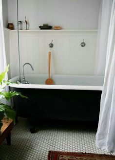 an old fashioned bathtub in the corner of a bathroom with white walls and flooring